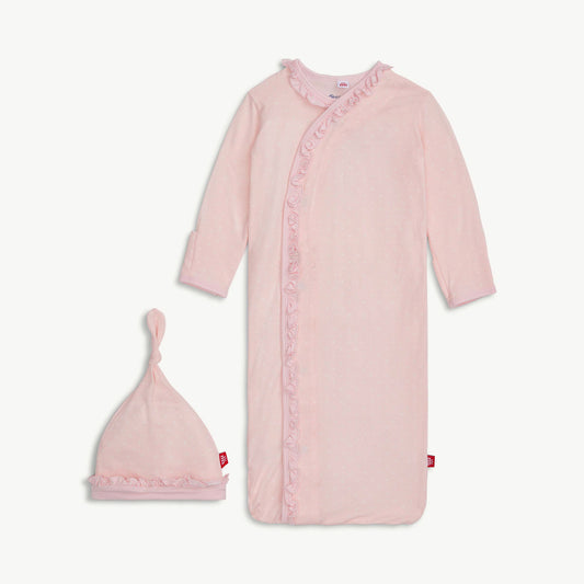 Pink baby gown with ruffles and matching hat on a light gray background