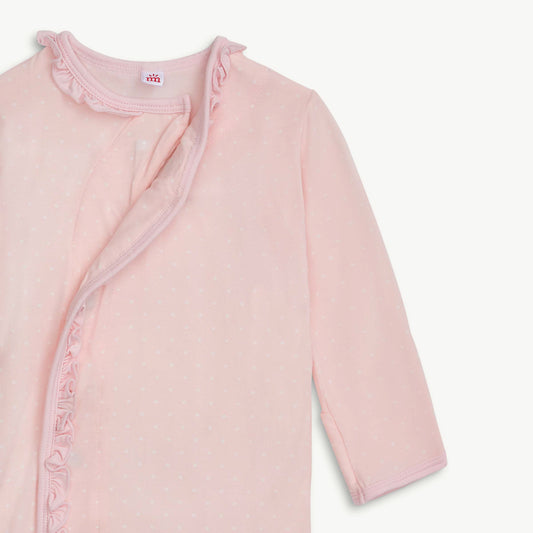 Pink baby jacket with ruffled details on a light gray background