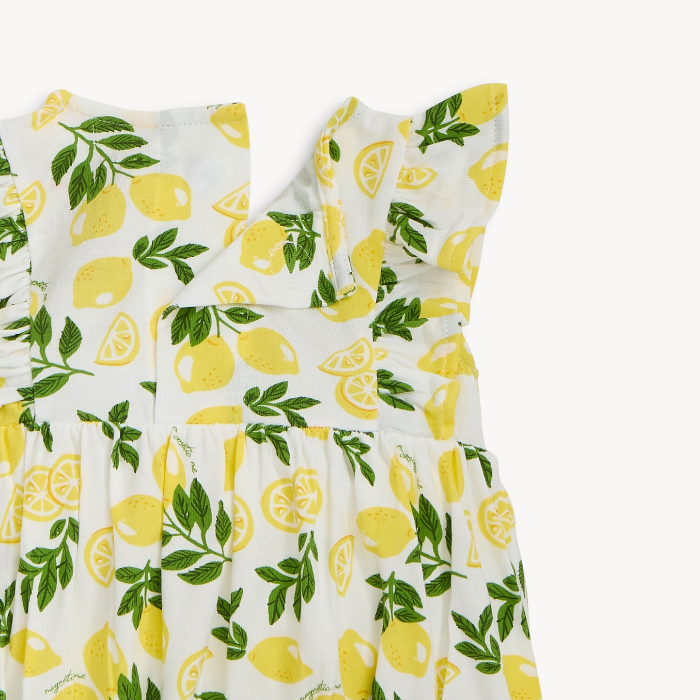 close-up of back closure with yellow lemon and green leaf pattern on a white background