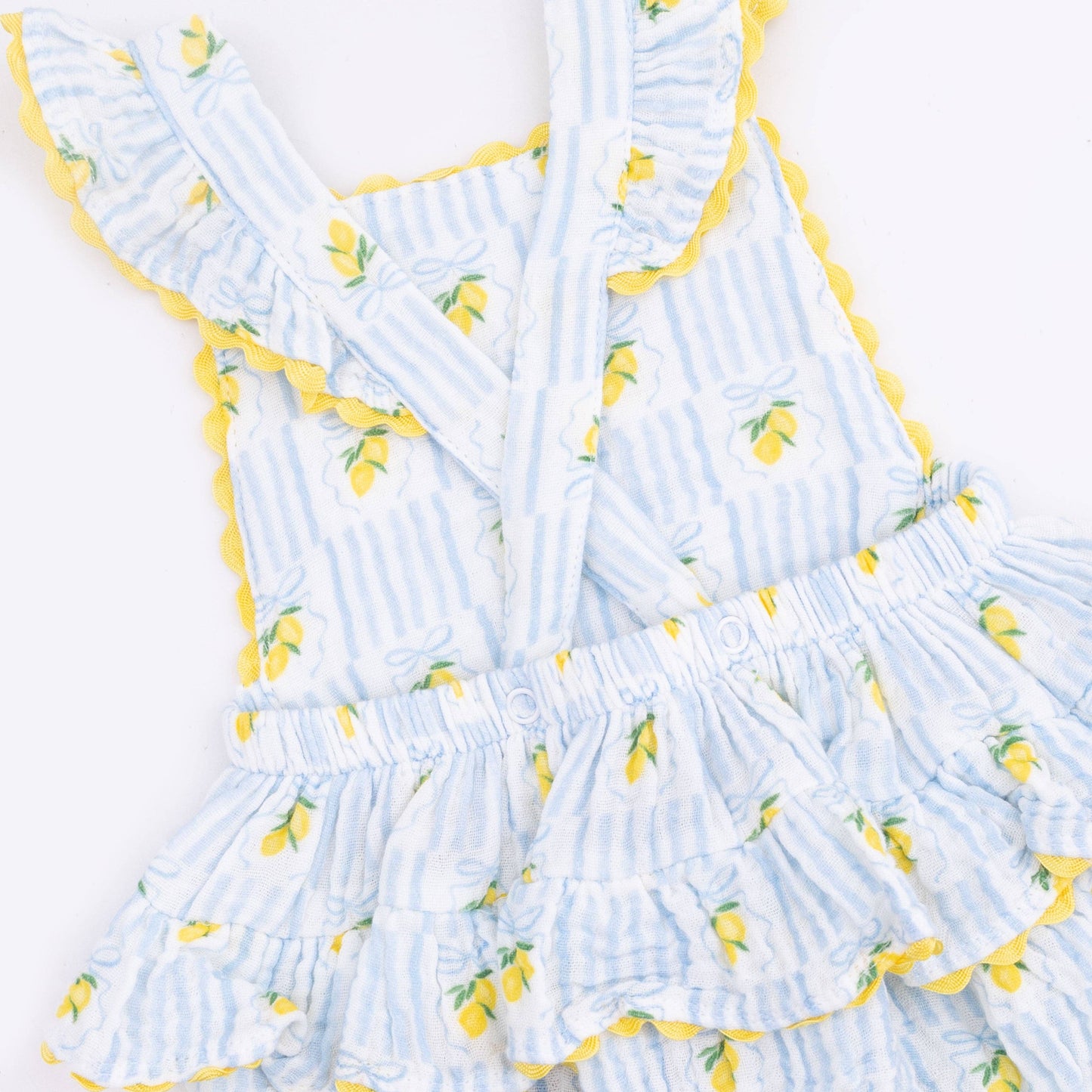 closeup of Light blue sunsuit with lemon pattern on a white background
