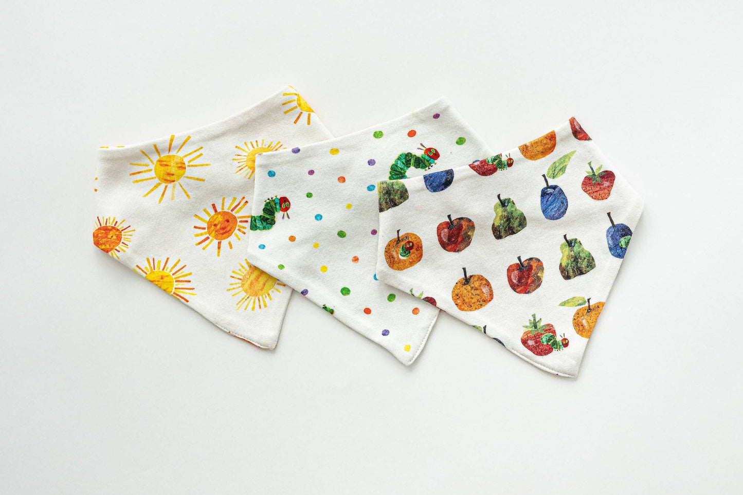Set of three baby bibs with colorful prints on a white background