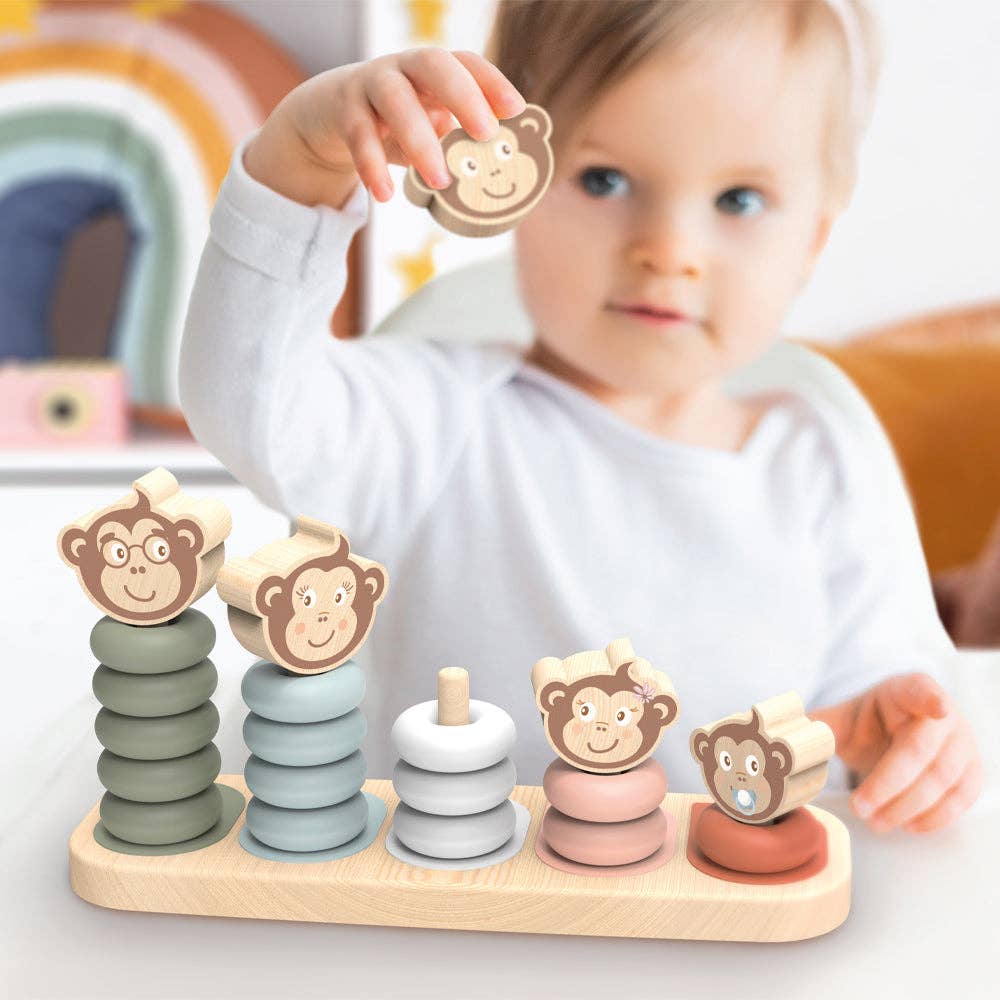 Child playing with a wooden toy featuring monkey figures on a light background