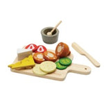 Play food set with a cutting board, vegetables, and utensils on a white background
