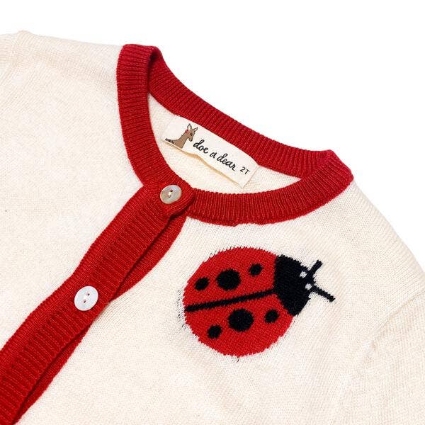 Children's sweater with red collar and ladybug design on a white background