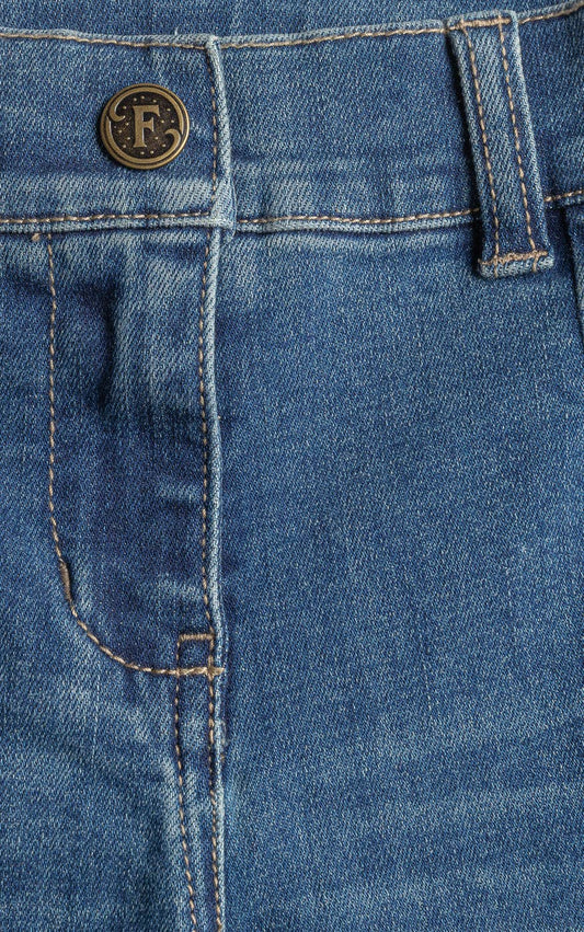 Close-up of blue denim fabric with a brand logo on a button.