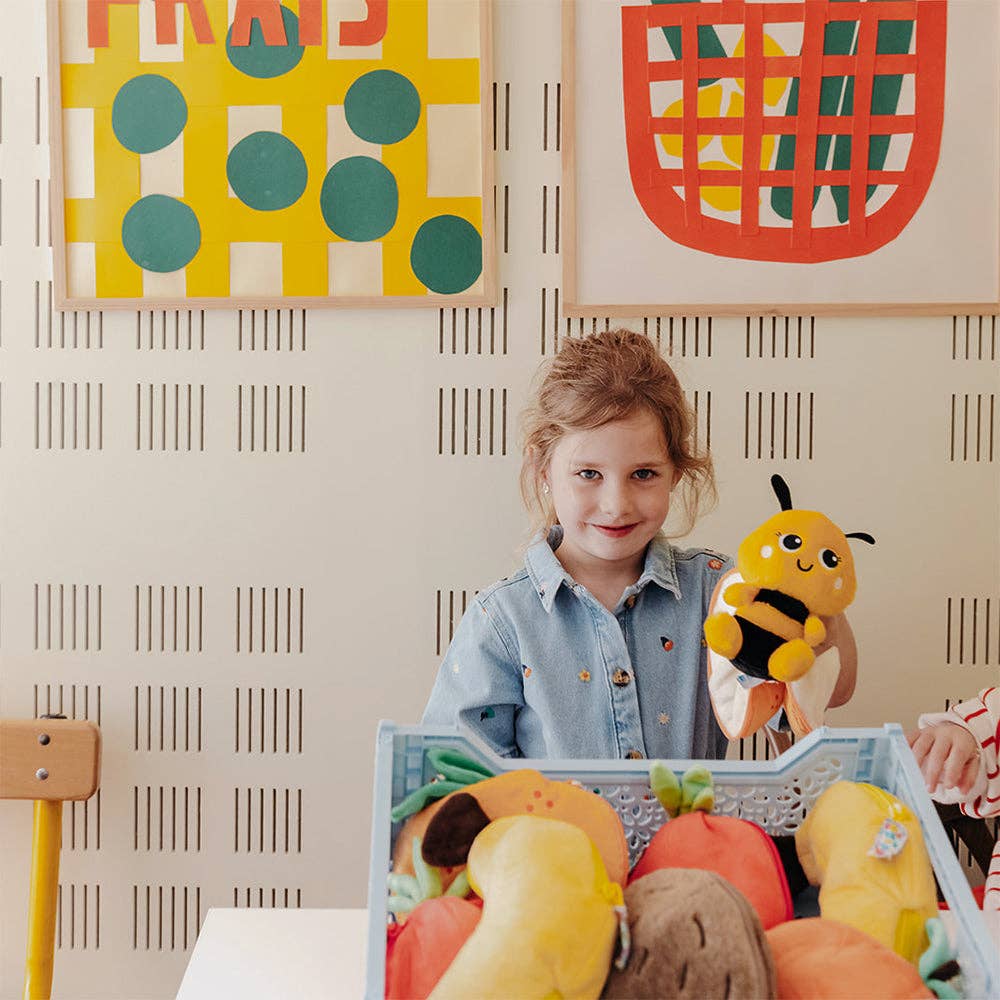 Child playing with toy Flipetz and vin a room with colorful abstract art on the wall.