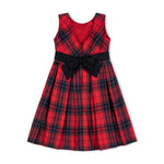 Red and black plaid dress with a large black bow on a white background