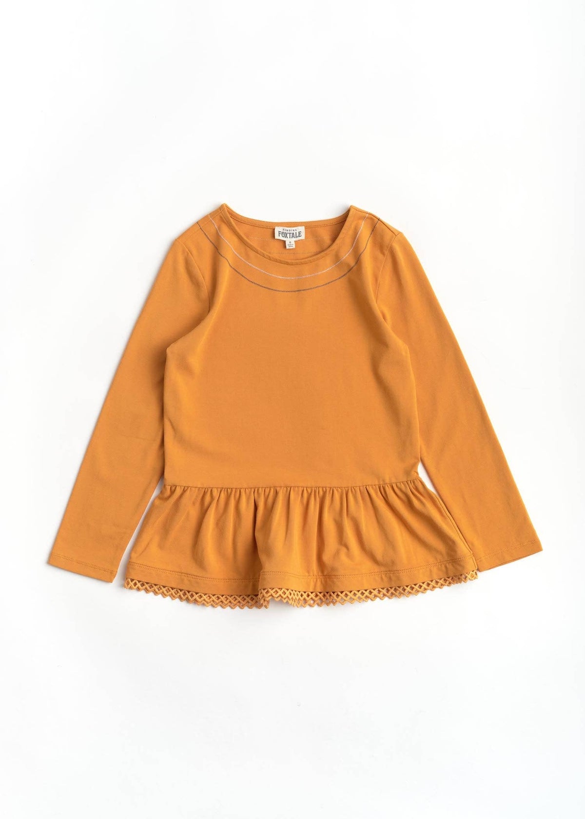 Orange long-sleeve top with ruffled hem on a white background