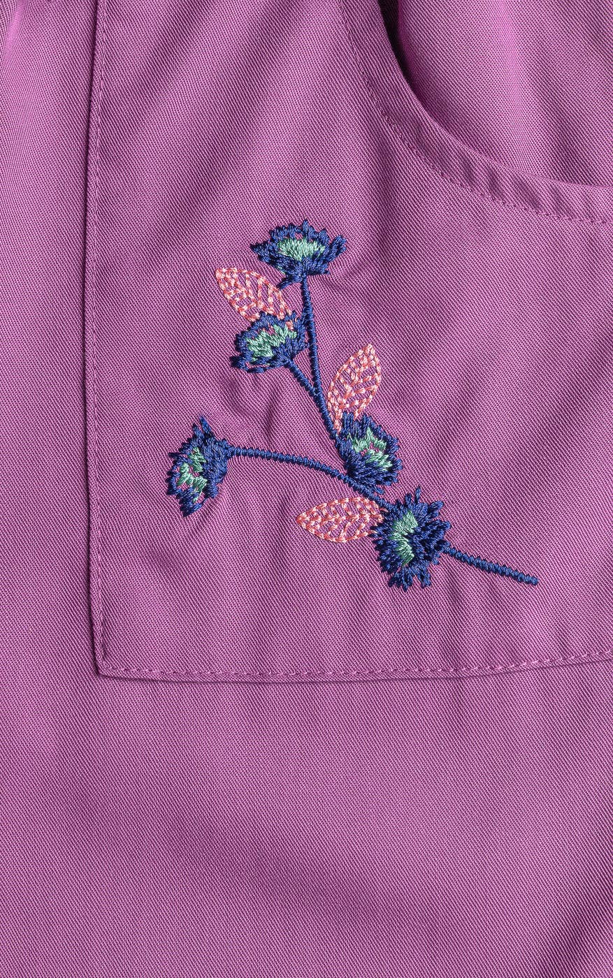 Embroidered floral design on a purple fabric