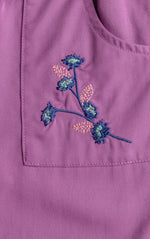 Embroidered floral design on a purple fabric