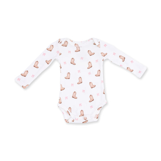 A white long-sleeve baby bodysuit featuring a repeating pattern of light brown cowboy boots and small pink bows, laid flat against a white background.