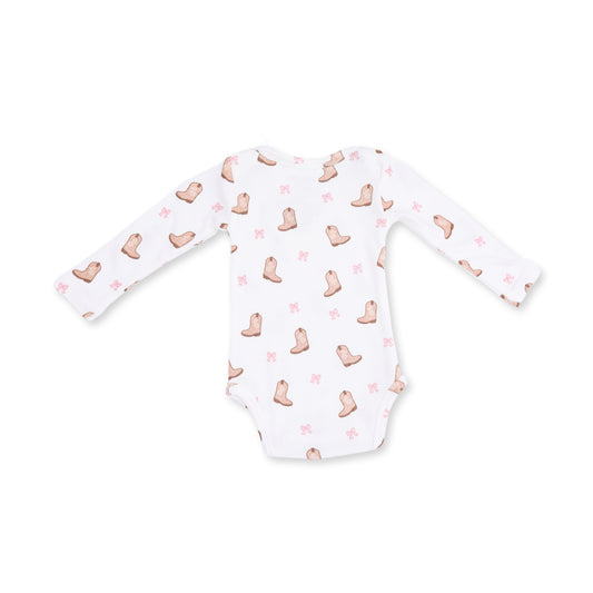 A white long-sleeve baby bodysuit featuring a repeating pattern of light brown cowboy boots and small pink bows, laid flat against a white background.