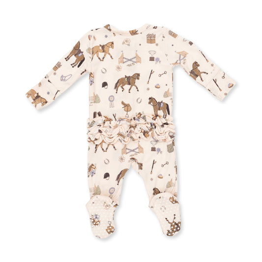 A baby long-sleeve footed sleeper in cream with an all-over equestrian-themed print of brown horses, reins, and bits, featuring a ruffled hem.
