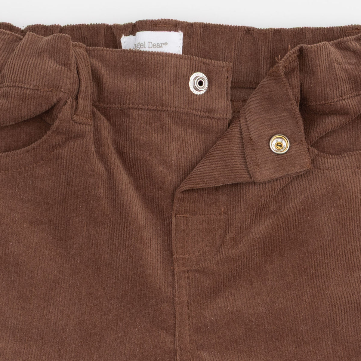 Close-up of brown corduroy pants showing the waistband, button closure, and inner label reading 'Sail Dyeing'.