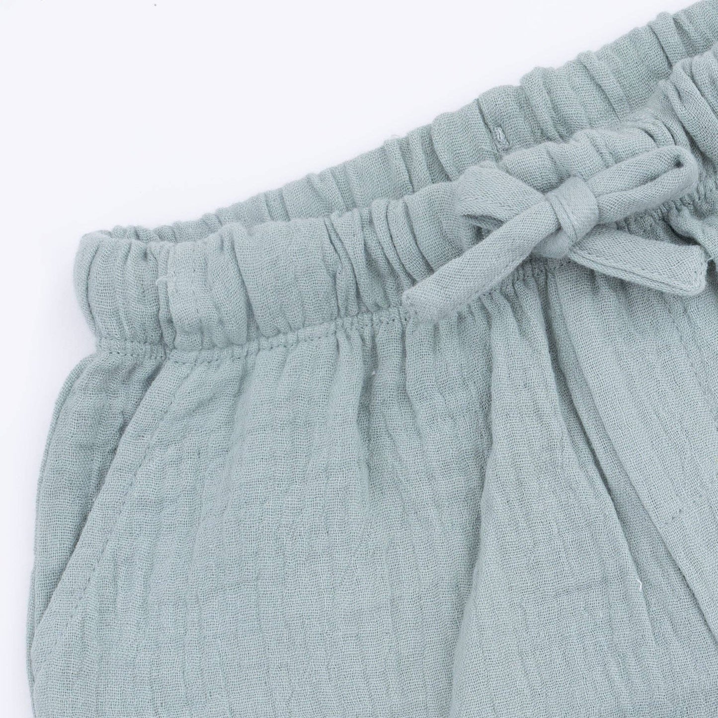 Light blue shorts closeup with a tie waist on a white background