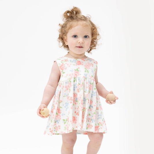 Young child wearing a floral dress on a white background