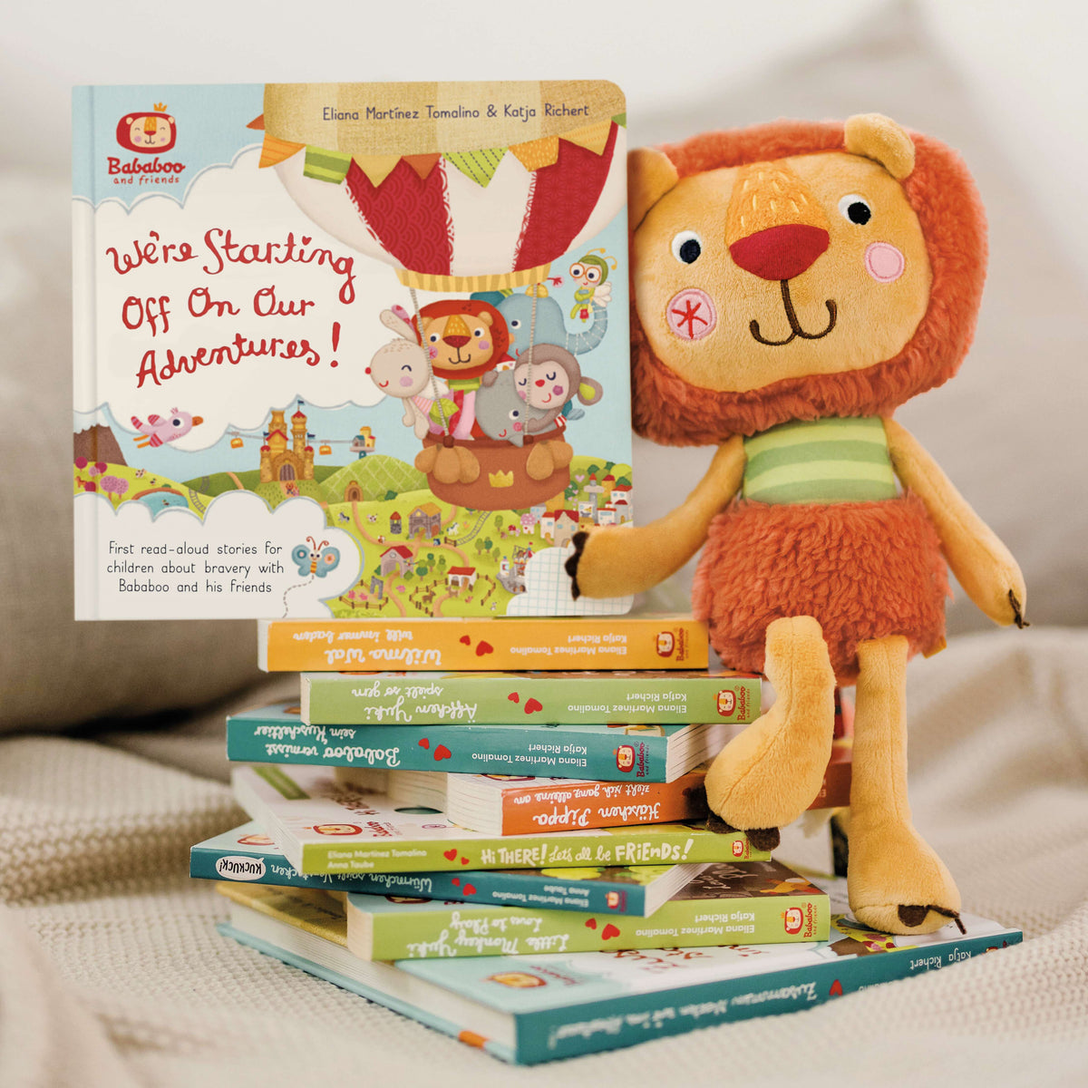 Bababoo children's books with Bababoo plush toy on a beige surface