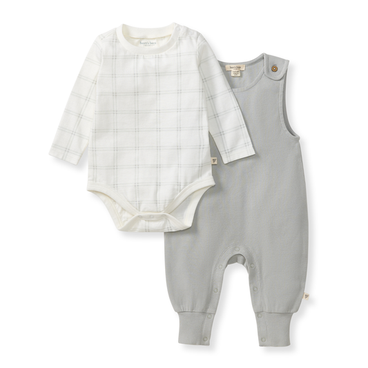 Baby outfit set with white bodysuit and gray overalls on a white background
