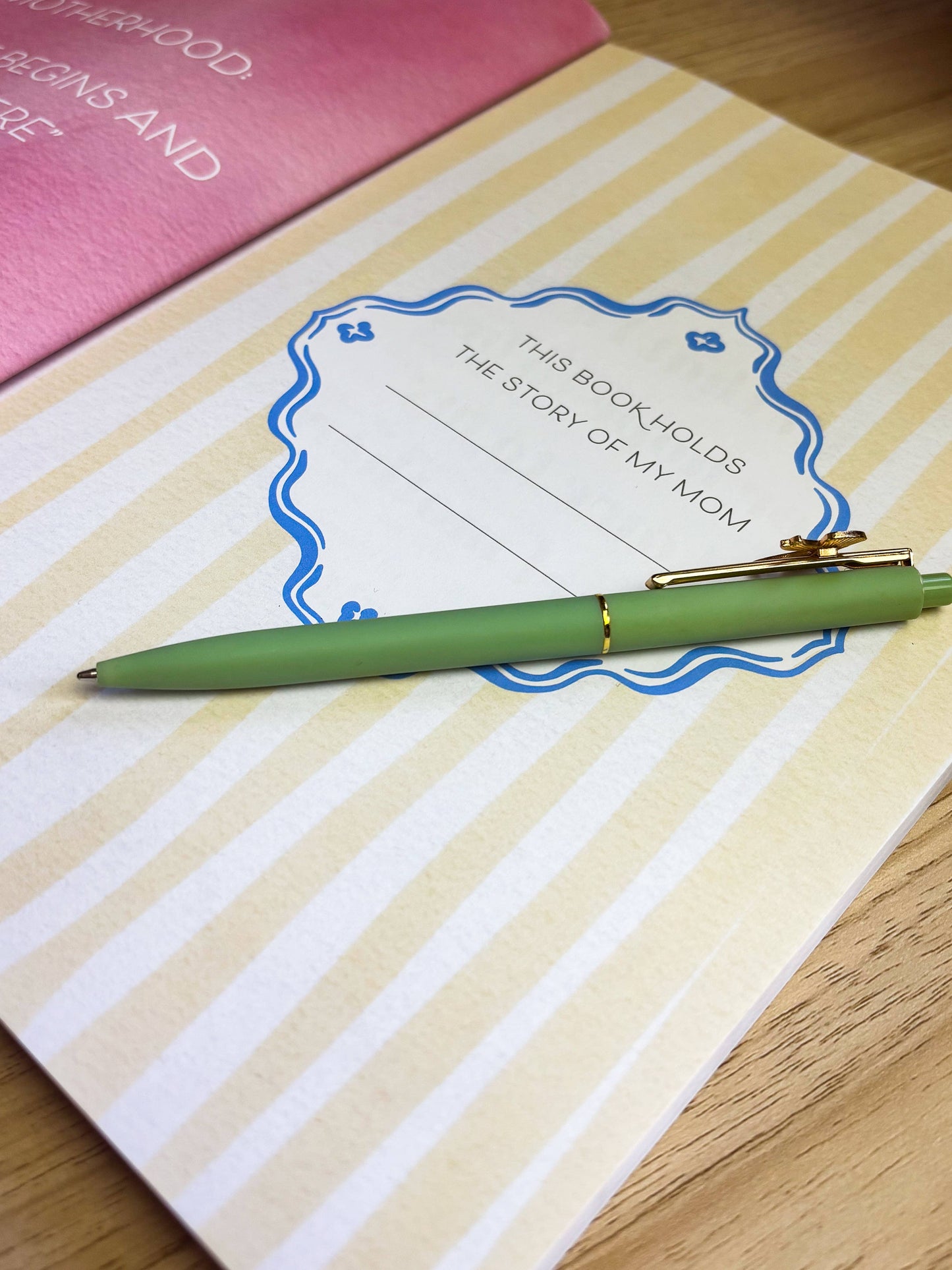 Notebook with a green pen on a wooden surface