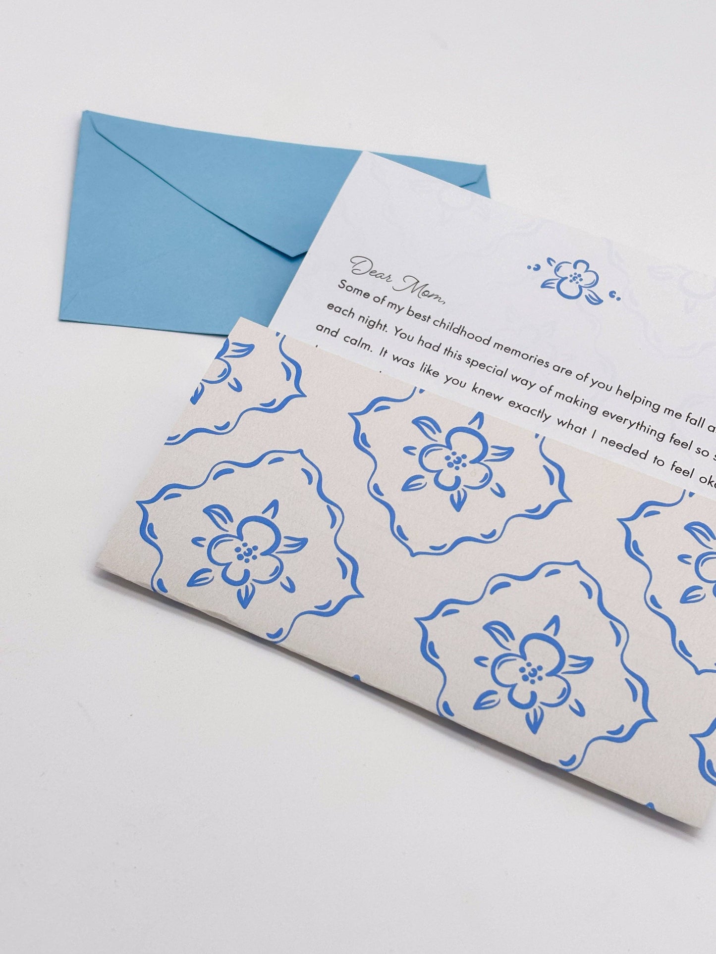 Card with blue floral patterns and a blue envelope on a white background