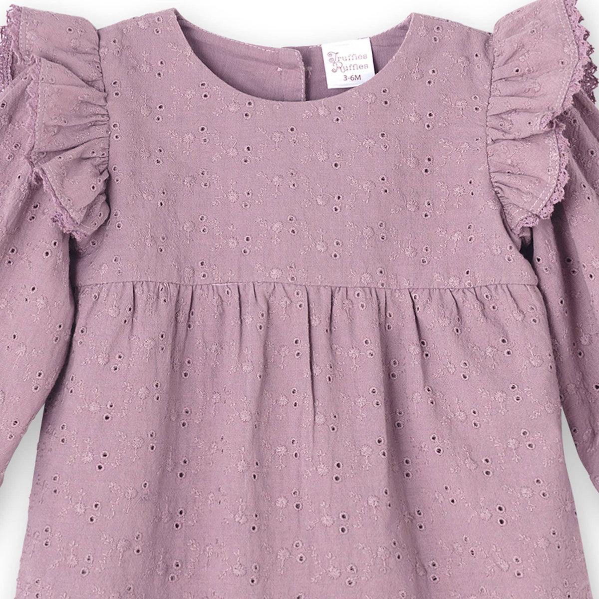 Close-up mauve eyelet romper with ruffled sleeves on a white background