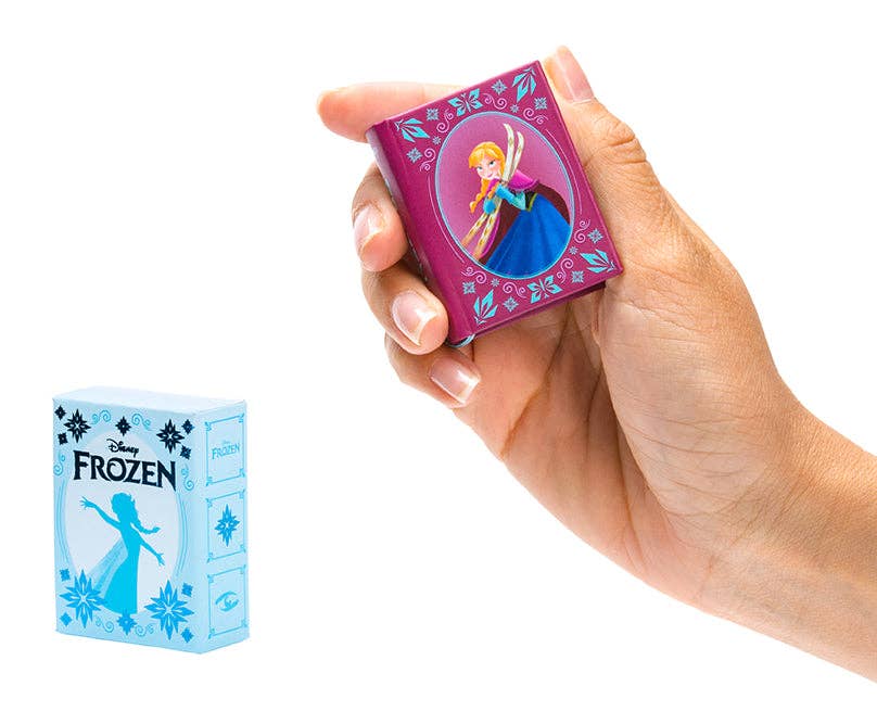 Hand holding a small 'Frozen' themed tiny book with a character on a purple box.