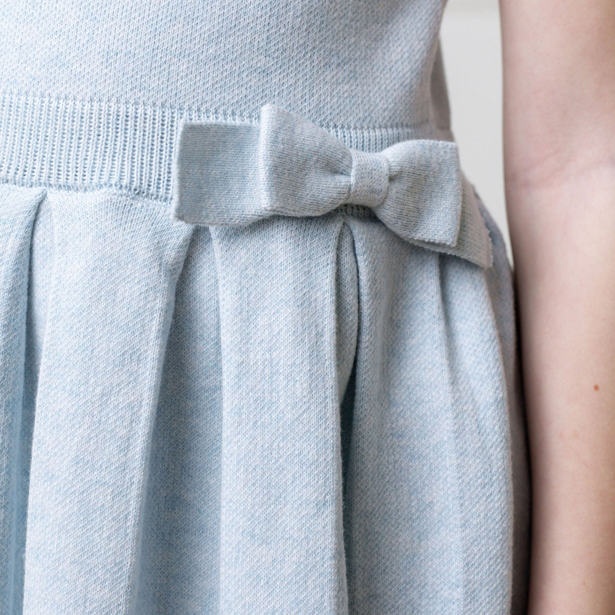 Light blue dress with a bow detail on a neutral background