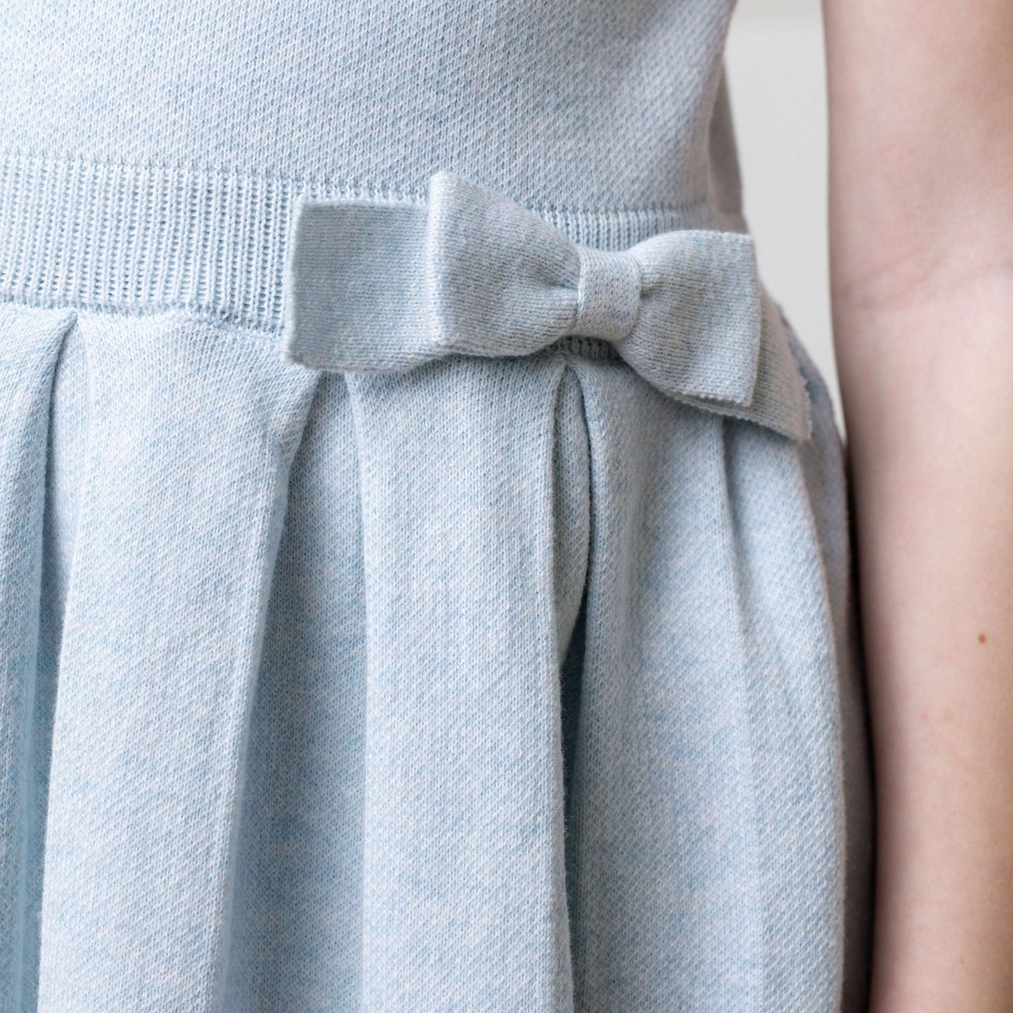 Light blue dress with a bow detail on a neutral background