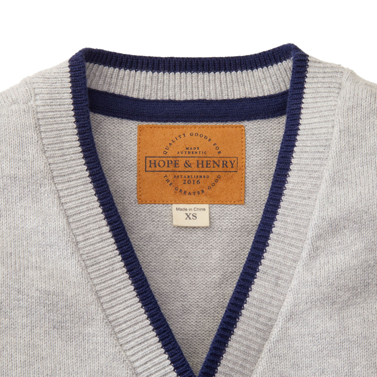Gray sweater with navy trim and a visible brand label on a white background
