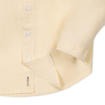 Close-up of a yellow striped shirt with a sleeve and button details on a white background