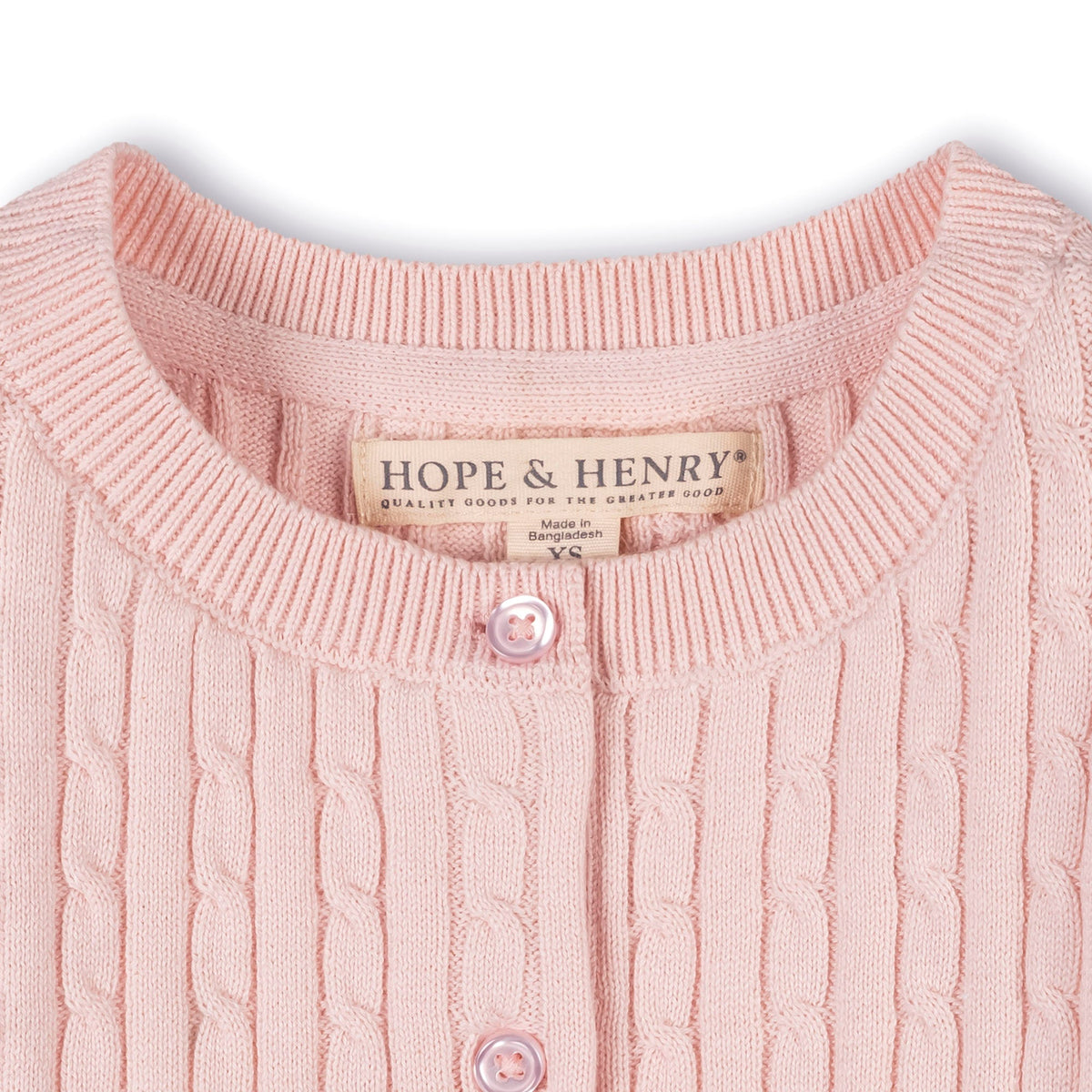 Close-up of a pink cable knit sweater with 'Hope & Henry' label.