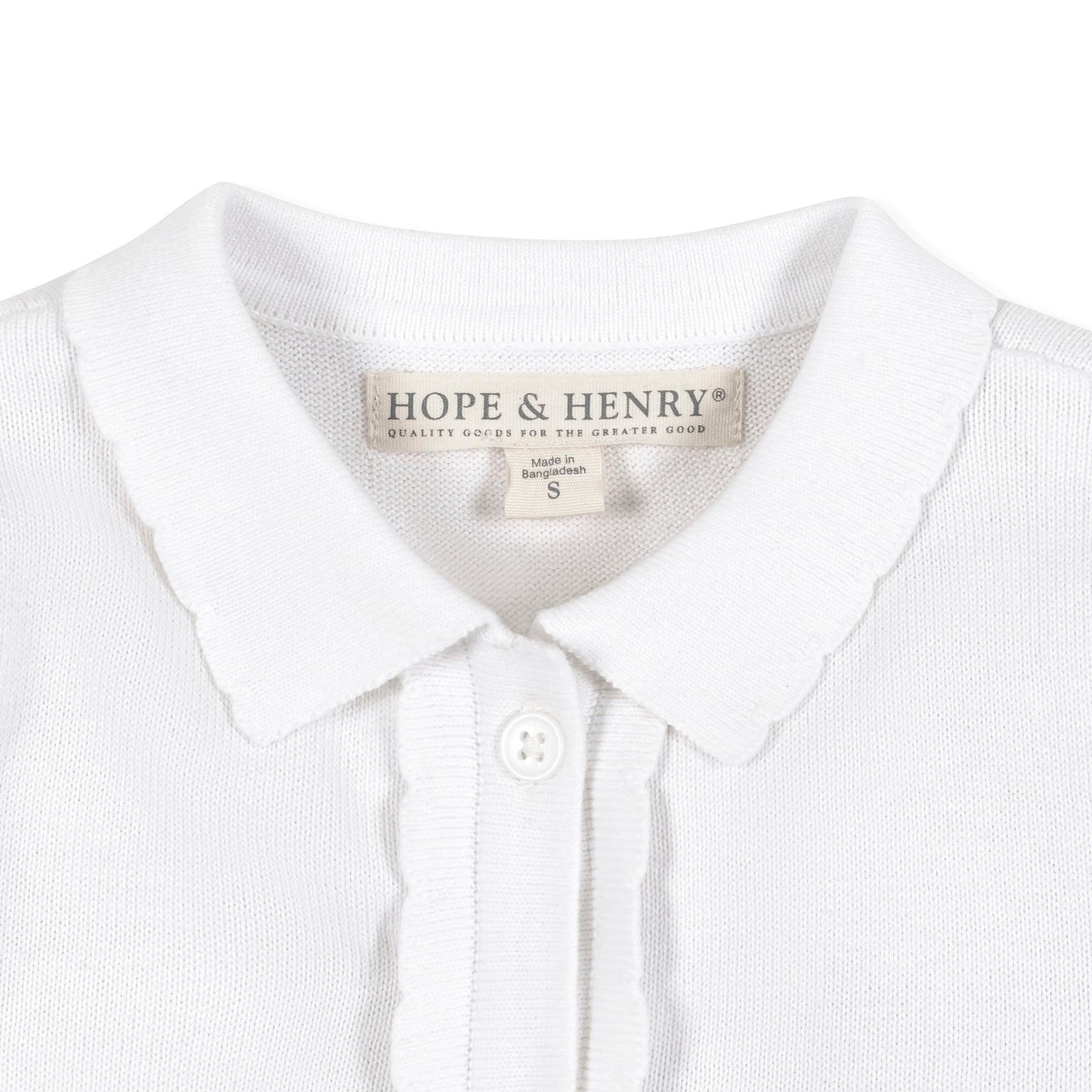 Close-up of a white sweater with a visible brand label on a white background