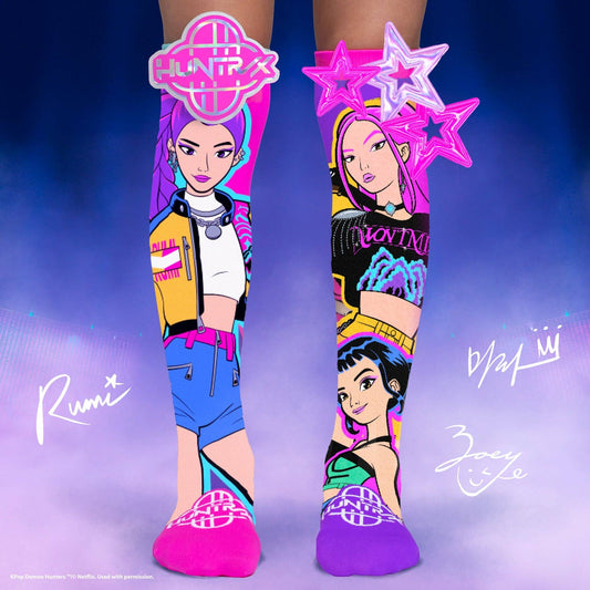 K-pop Huntrix socks with character designs and branding on a blue and purple gradient background.