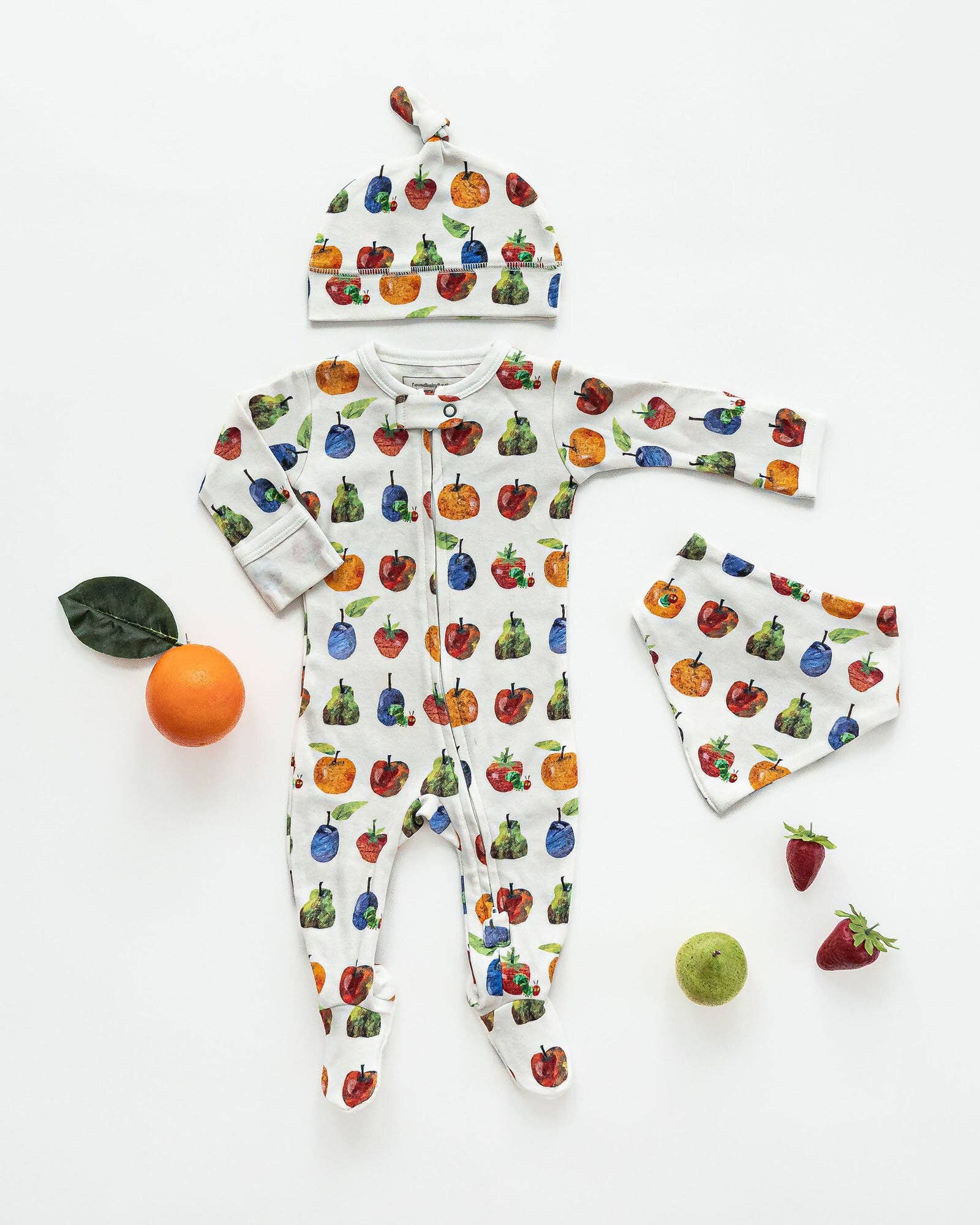 Baby onesie and hat set with fruit pattern on a white background