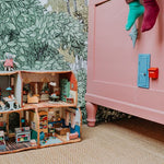 mouse door attached to pink bed, surrounded by green leafy wallpaper.
