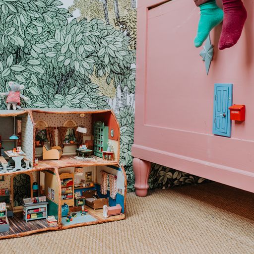 mouse door attached to pink bed, surrounded by green leafy wallpaper.