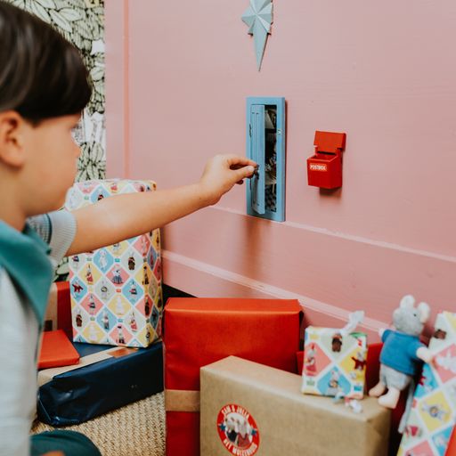 Child playing with a little mouse door in a colorful playroom
