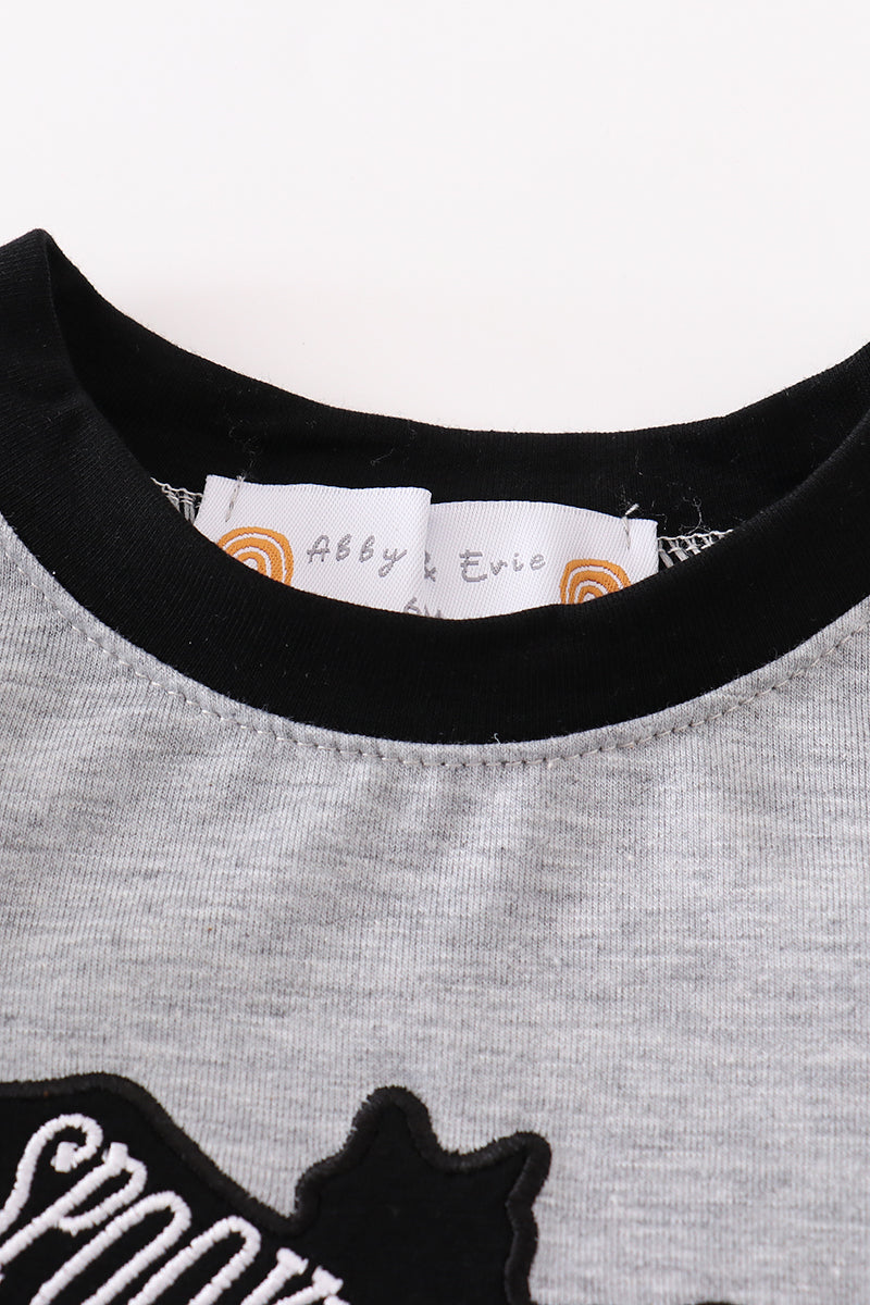 Gray shirt with black cat design and brand label on a white background