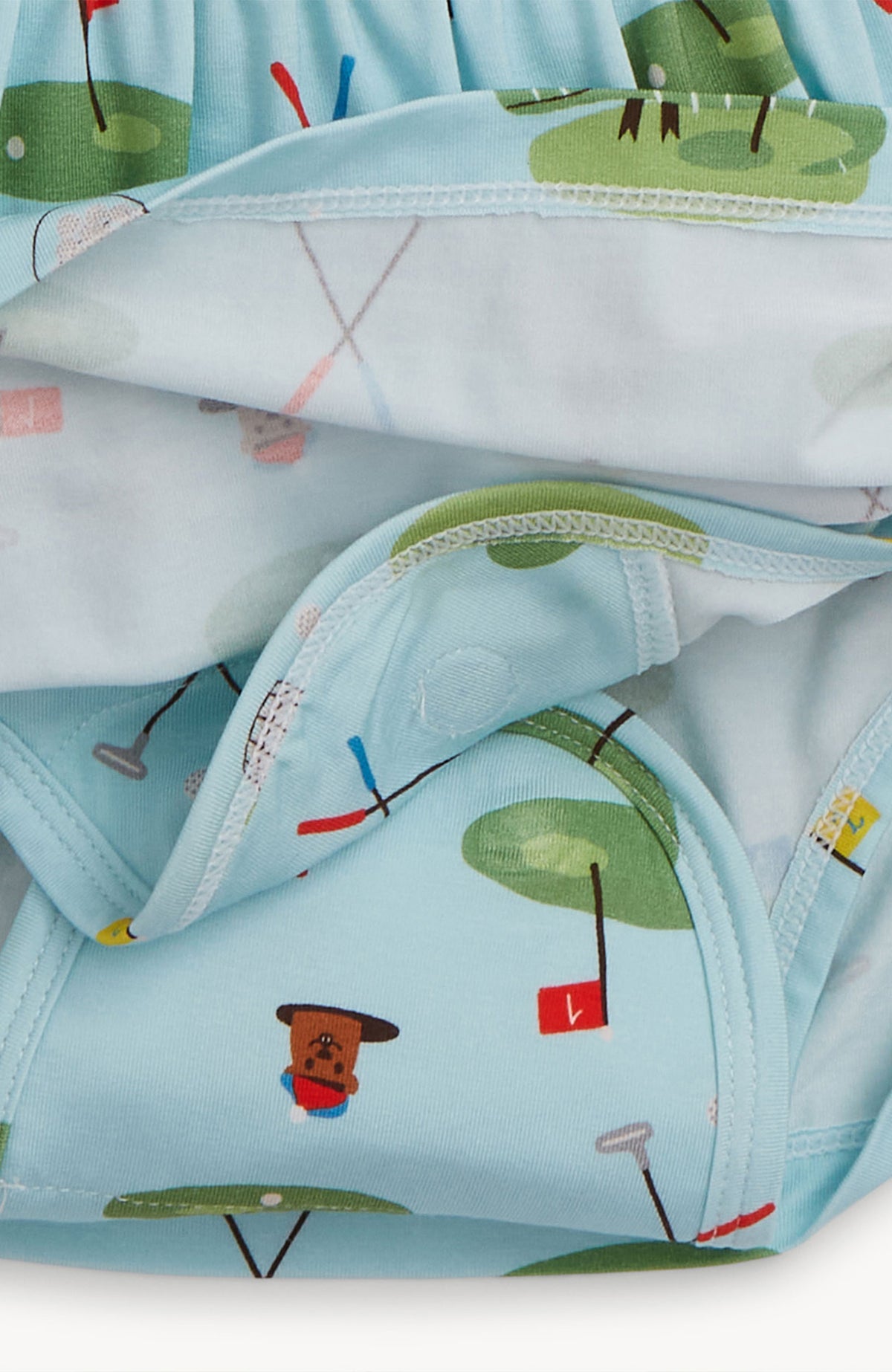 Children's body suit with golf-themed print on a light blue background