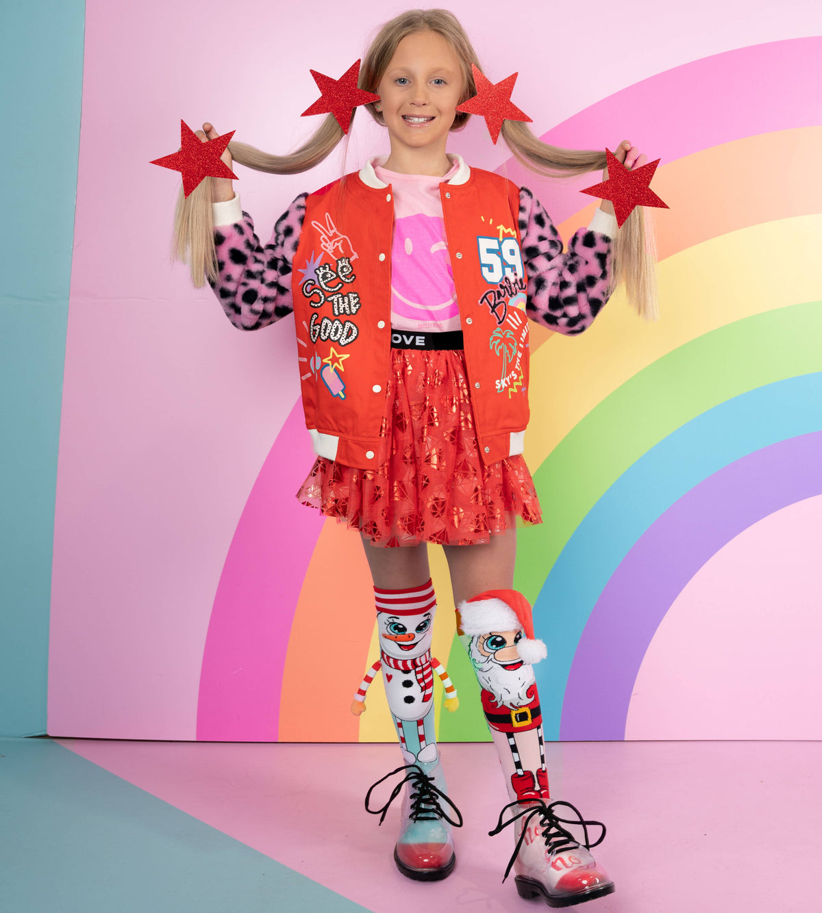 Young girl in a colorful outfit with a rainbow background