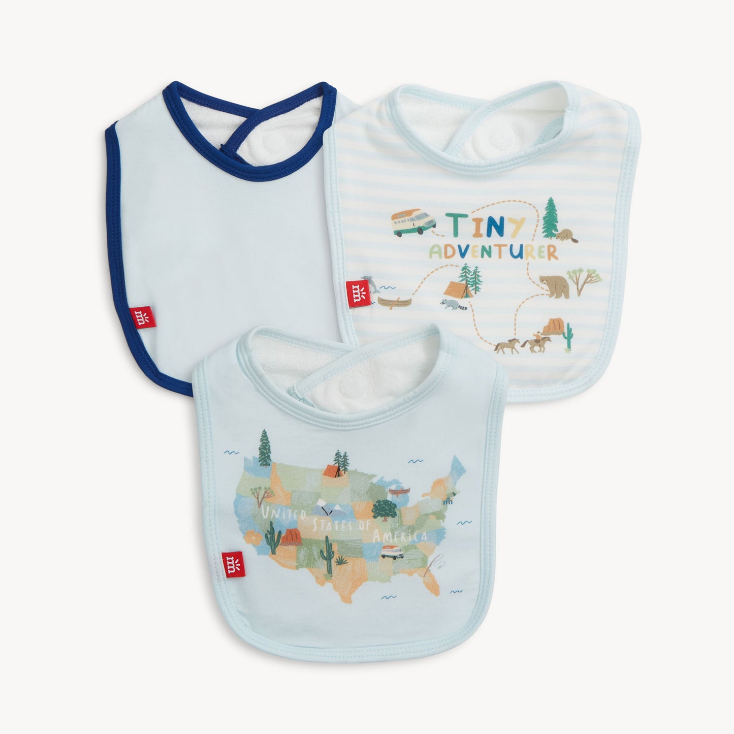 Three baby bibs with 'Tiny Adventurer' and map designs on a white background