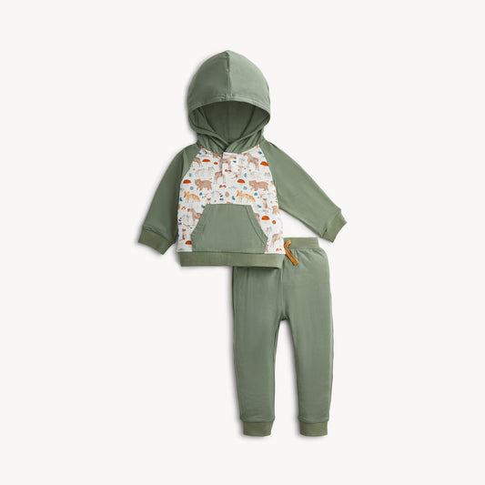 A toddler's two-piece matching set consisting of a sage green hooded sweatshirt with a white patterned chest panel and matching sage green jogger pants, displayed on a clean off-white background.