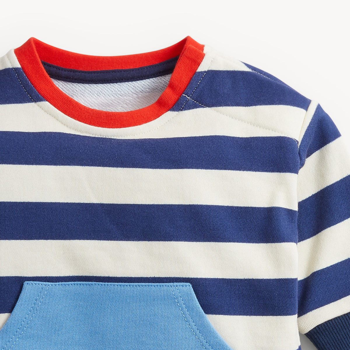 Close-up of a striped short-sleeve top with navy and off-white horizontal stripes, a red ribbed crew neck, and a light blue front pocket.