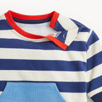 Close-up of a children's shirt with blue and white stripes and red collar on a light gray background