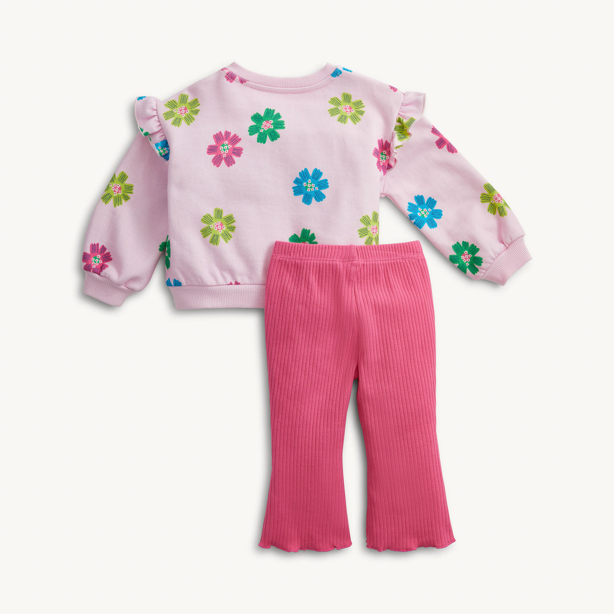 A toddler girl's two-piece outfit featuring a light pink long-sleeve top with colorful flower prints and ruffled shoulders, paired with bright pink ribbed flared leggings, shown on a plain off-white background.