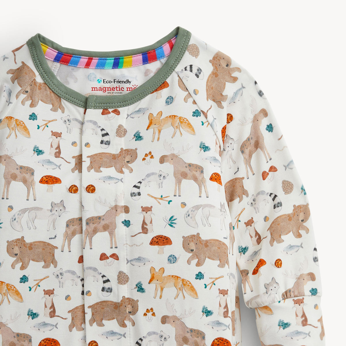 A close-up of a baby long-sleeve sleep shirt with a woodland animal print on an off-white background. The print features brown bears, foxes, raccoons, squirrels, and mushrooms, with a green collar and a colorful striped inner neck lining.