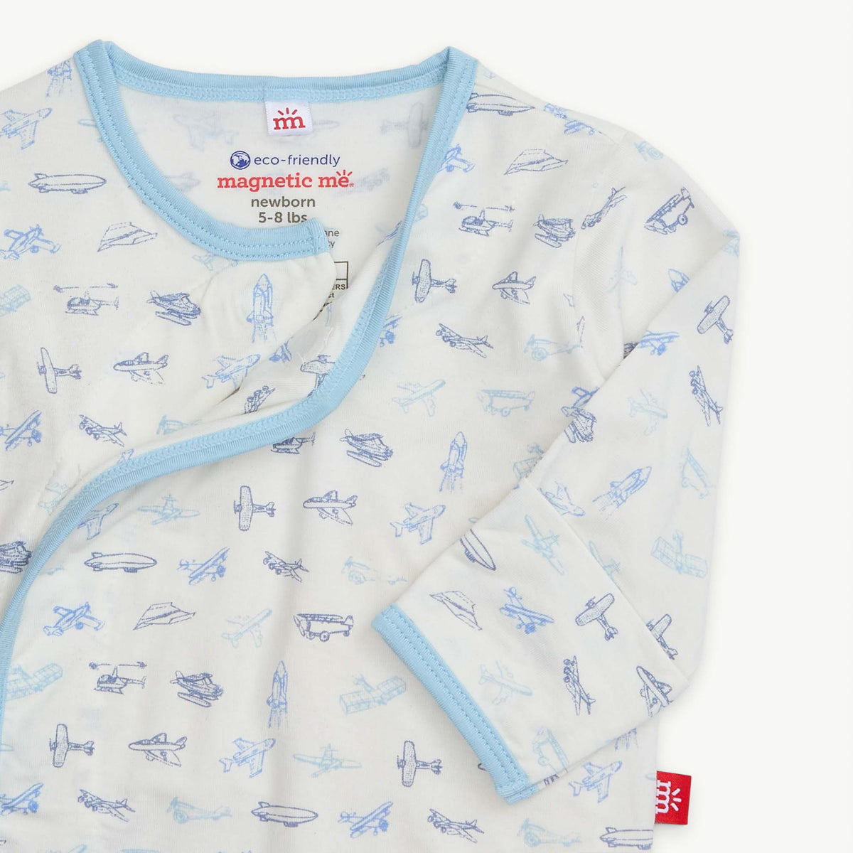 Baby wrap with airplane pattern and blue trim on a white background