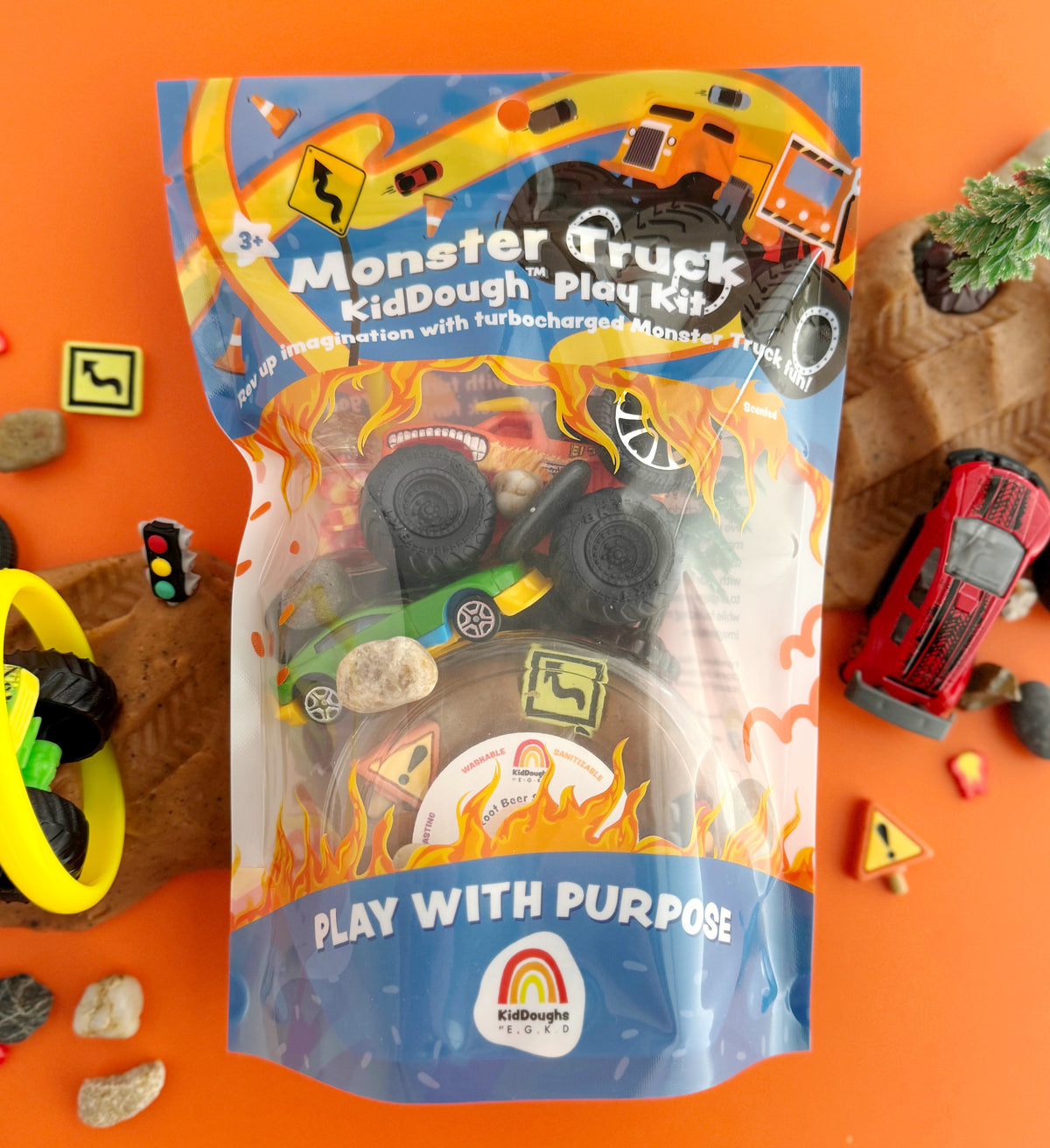 Monster Truck KidDough Play Kit packaging on an orange background with toy cars and traffic lights.