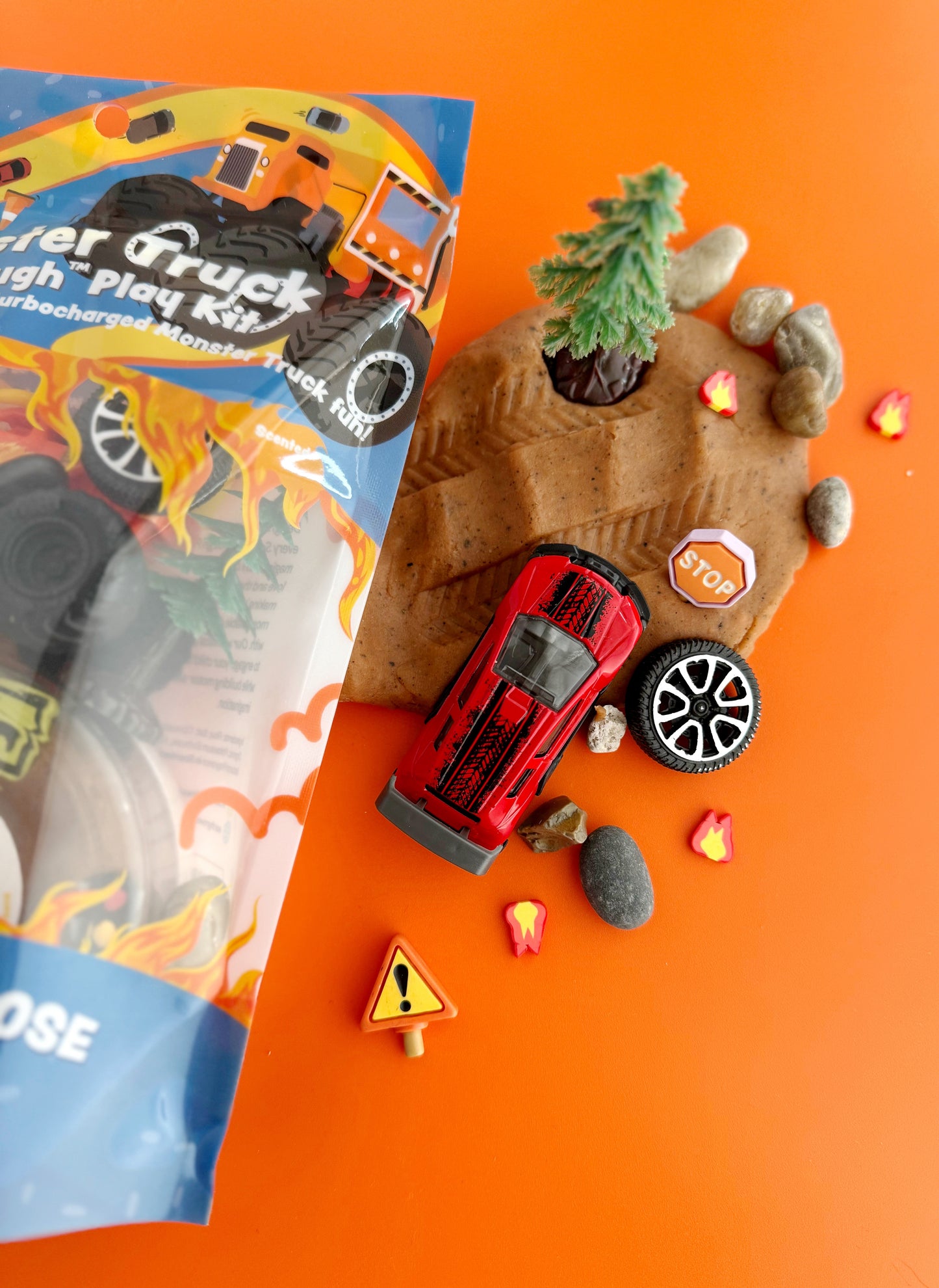 Toy truck and accessories on an orange background with a toy truck packaging.