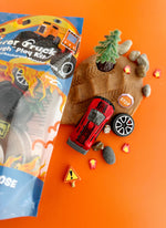 Toy truck and accessories on an orange background with a toy truck packaging.